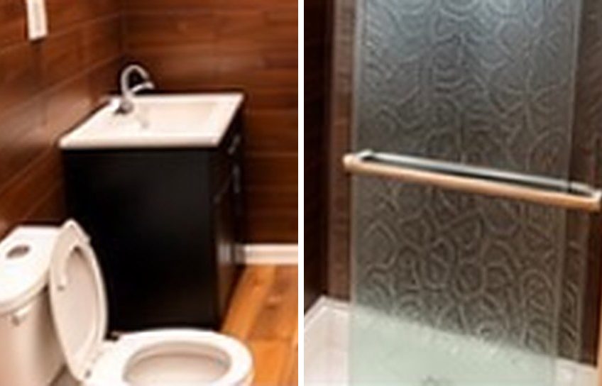 Bathroom with dark wood walls, a vanity and toilet, and a shower with a patterned glass door
